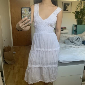 Vit klänning - En vit söt klänning som passar studenten eller skolavslutning. Virkade detaljer och knyts i ryggen för att bli tajtare i midja. Barn l/xl och skulle säga att den passar en S. 💓