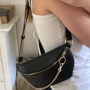 Väska  - Använt denna typ 3 gånger. Ingen skada eller så. Ser ut som ny. Använt den som axelväska för några år sedan. Svart med guld och  ljusrosa på insidan. Fin,Skin material. Kan göra den längre eller kortare. Smutsig spegel och kamera så det är inget sånt på.