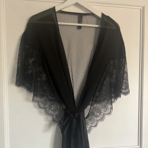 Kimono i spets - Svart kimono i spets med sidenband från hunkemöller, ny aldrig använd.