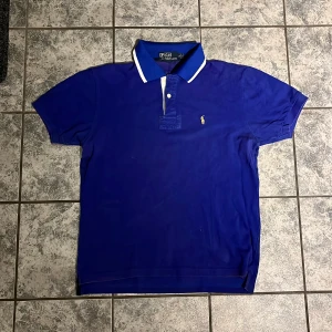 Pikétröja från Ralph Lauren  - Blå piké från Ralph Lauren. Storlek M