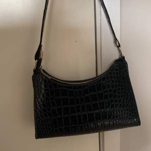 En svart handväska med orm mönster, den är knappt använd och i mycket bra skick.