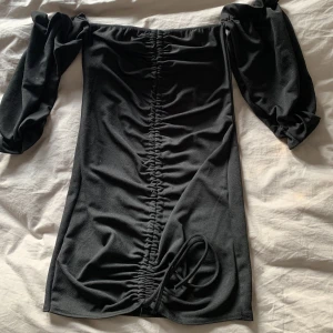 Klönning - Off shoulder med trekvarts-ärm. Går att ändra längd genom att knyta. Figurnära. 