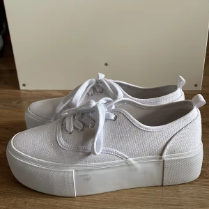 Höga canvasskor - Vita skor i canvas med hög sula, från Hm! Jättefint skick då de endast är använda en gång, finns någon fläck på sulan och inuti skon därav det låga priset💞