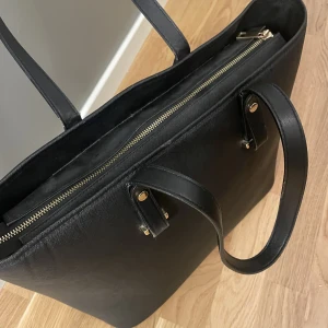 Svart handväska - Svart rymlig väska som inte kommer till användning längre, finns en liten rosa fläck (sista bilden)