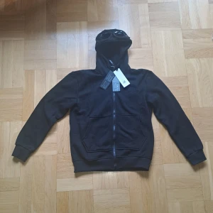 C.P. Company hoodie - Säljer en oanvänd cp company hoodie i färgen svart, storleken är M men passar S. Skickas eller möts upp i Stoclholm. Pris kan alltid diskuteras vid snabb affär.