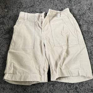 Beiga cargo shorts med vita sömar. 