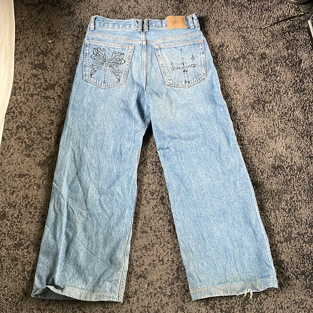 Jätte snygga Baggy jeans med design på bakfickorna. Dom är ganska slitna vid hälen men inte jättemycket, annars är dom i bra skick . Jeans & Byxor.