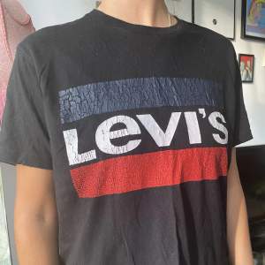 Snygg Levi’s t-shirt, svart med den klassiska loggan. Älskad och använd därmed lite ”sprickor” i trycket (gör den dock bara coolare). Den är även något lite croppad(avklippt) nedtill, syns i bild 3.
