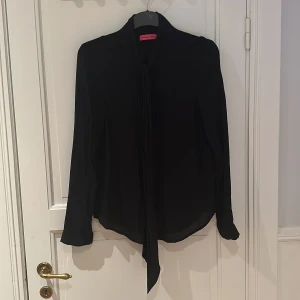 Knytblus Veronica virta - Svart knytblus i storlek L 100 % viskos. 