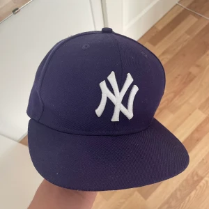 Fitted Keps - Lila Fitted New Era yankee keps i storlek 54,9cm - 6 7/8. Tecken på använding finns. Säljer pga för liten. 