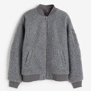 Säljer oanvänd jacka från H&M i grå ”ull” vadderad bomberjacka. Divided. Silver detaljer med dragkedja. 