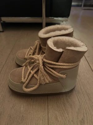 Inuikki boots - Inuikki ’moon boots’ i fint skick! Fårskinn med mocca detalj i färg sand! Använda 2 ggr