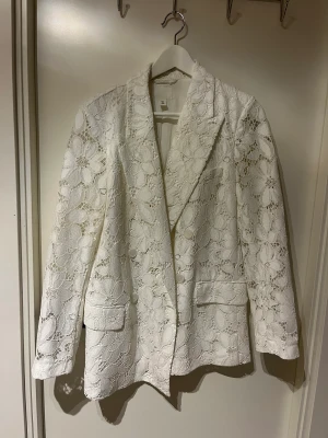 Vit spetskavaj - Jättefin vit kavaj. Armarna är utsvängda i ett fint spetstyg. Kavajen är aldrig använd så i nyskick! 