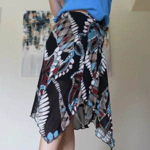 Asymmetrisk midikjol  - Märke: Morgan Strl: XS-M Modell: asymmetrisk (lettuce hem), snörning på sidan Material: 100% polyamid  Skick: Använt skick