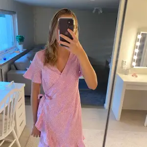 Super söt, rosa-prickig klänning med volang och knyte i sidan!