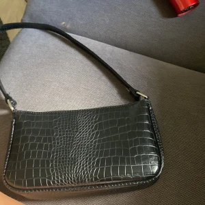 Svart väska -  Jag säljer en svart väska som är helt oanvänd. Den kommer inte till användning på grund av att jag har så många.  Den har tre fack var av ett har dragkedja. (köparen står för frakt)