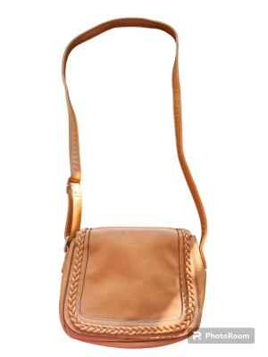 Axelremsväska  - Fin axelremsväska i bra skick. Två små fickor på dragkedja, hela väskan knäpps med en knapp.