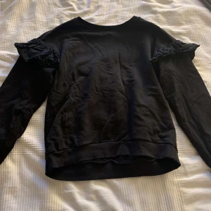 Sweatshirt med volang. - Sweatshirt med volanger på ärmarna. Bra skick. Storlek: S