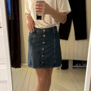Jeanskjol  - En jeanskjol med knappar hela vägen som går att knäppa upp. Fel fri 