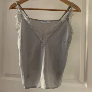 Topp NA-KD - En OTROLIGT fin topp med spets från NA-KD, ÄLSKAR, V-Neckad, i en fin blå färg! Är absolut öppen för prisförslag, kan mötas upp i Stockholm och det är bara att skriva för fler bilder!