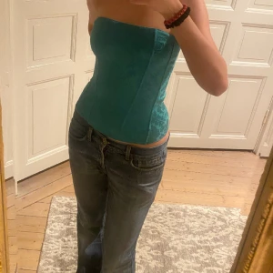 Blågrön korsett - Galet snygg blågrön korsettopp med underbart glansigt mönster💞Perfekt till fest! Fint skick bortsett från någon liten fläck (knappt synligt). Passar XS-S. Skriv vid funderingar och kolla in mina andra annonser🪩🎀