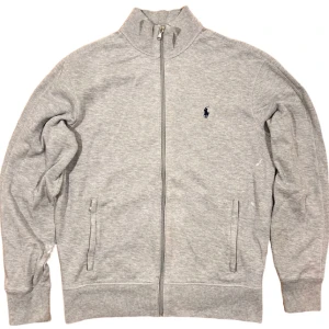 Ralph Lauren Full-Zip Tröja - Grå fullzip tröja från Ralph Lauren. Tröjan har några missfärgningar men är bortsett från det i bra skick. Storlek S, ställ gärna frågor!😊