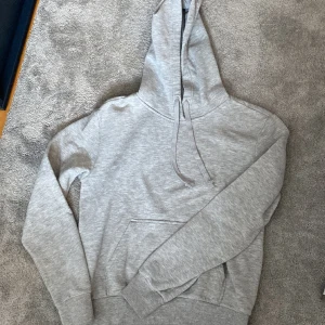 Grå hoodie - Säljer denna gråa hoodie från HM. Finns inga tecken på användning dock så är den lite nopprig på armarna men ingen som syns eller känns på. Säljer då den blivit för liten. Hör av er vid funderingar eller fler bilder💕