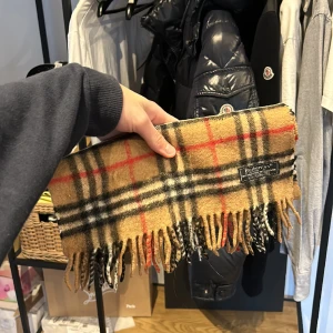 Burberry Halsduk - Vintage burberry halsduk i okej skick, 8/10. General wear och inget som syns på avstånd, bra skick för att vara vintage! 50% lammull och 50% cashmere. Nypris 4600kr mitt pris 800kr! Bara att skriva vid frågor eller funderingar :)