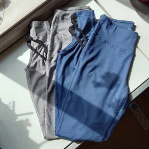Två Träningsbyxor - Säljer två träningsbyxor, en blå och en grå med fina korsade detaljer längst ned💕 kontakta om du endast vill köpa ett par🫶