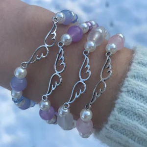 Pärlarmband ängel - Handgjort pärlarmband av glaspärlor i olika färger. Vingar och lås i metall. Skriv till mig för att välja vilken/vilka färger. Kan förlängas med kedja utan extra kostnad. Perfekt present till syster eller bästa vän❤️