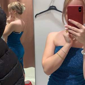 Säljer denna glittriga blå klänning som är supersnygg till nyår, aldrig använd🩵den har avän slits där bak som man ser på den första bilden 