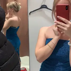 Säljer denna glittriga blå klänning som är supersnygg till nyår, aldrig använd🩵den har avän slits där bak som man ser på den första bilden 