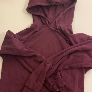 djup vinröd lila hoodie  - har haft den ett tag men kommer knappast till användning :) inga stora täcken på användning mer än snörena som har sätt aningen bättre dagar 