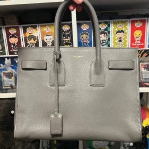 Saint Laurent Sac De Jour Small - Ysl handväska i super fint skick. Finns dock en liten skada på baksidan där ena knappfästet gått av. Nypris - 30000kr
