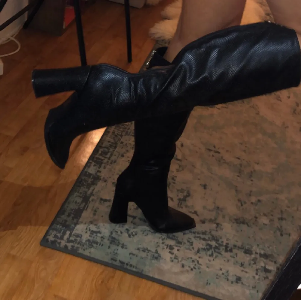 Svarta knä långa boots i bra skick i strl 7, (40) är i svart hår klacken är 10cm. Skor.