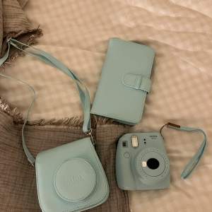 Instax mini kamera med tillhörande väska och fotoalbum. Allt i fint skick