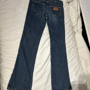 Säljer dessa jättesnygg jeans den Wrangler  Storlek w 39 L 34  Midja 39 cm Insida ben 80 cm Total längd 104 cm