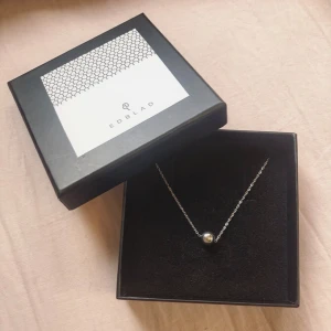 Halsband ifrån Edblad - Ett silverfärgat halsband ifrån Edblad med en liten boll som hänge. Halsbandet är knappt använt så är i bra skick, lådan är däremot lite repig och har smuts på sig, försöker få bort mycket av det. Hör av dig om du undrar nåt🌸