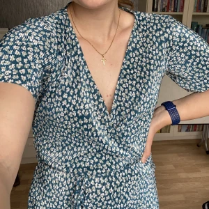 Blommig byxdress - Turkos byxdress från Pull&bear som ser ut som en klänning. Färgen syns bäst på tredje bilden. Sparsamt använd och i gott skick!