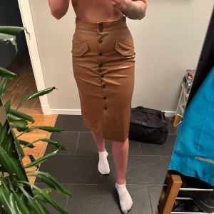 Skinn imitation kjol - Kjol från hm i skinn imitation. Knappar fram och fick detaljer. Sparsamt använd. 