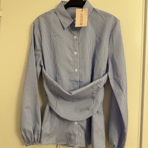 Skjortklänning/blus - En helt oanvänd skjortklänning/blus från missguided i storlek 34.