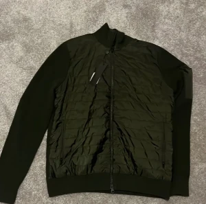 J Lindberg cardigan - Säljer nu denna mörk gröna j Lindberg cardigan i storlek M. Den är helt ny och aldrig använd pris lappen sitter kvar 