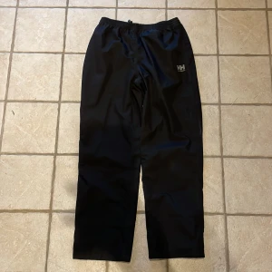 Helly Hansen regnbyxor - Svarta regnbyxor från Helly Hansen i superfint skick, inga hål eller fläckar! 🤩 storlek 152 / 12 år.