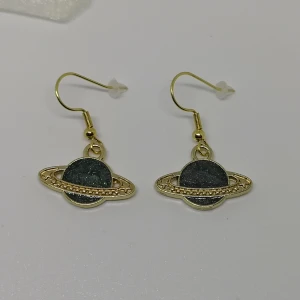 Örhängen - saturnus  - Örhängen gjorda/designade av mig. De är nya/oanvända. Krokar i rostfritt stål. (frakt: 15 kr för frimärke) 