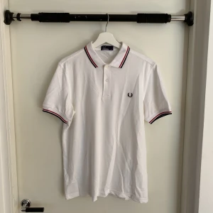 Fred Perry piké i nyskick!  - Stilren vit Fred Perry pike i nyskick! Aldrig använd. Har legat i min garderob i ca 1 år. Nypris 900 kr. 