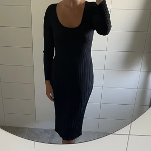 Mörkblå klänning - Jättefin klänning. Tungt material som faller väldigt fint. Den är sydd på något sätt så att den går in lite i midjan och sen går den rakt ner. Så den är inte tight längst ned