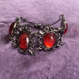 Armband  - Vackert armband med rubinröda stenar  Okänt material 