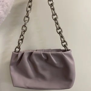 Lila väska med silverkedja - Lila handväska från H&M. Aldrig använd. 