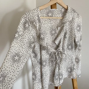 Blus med stjärnor  - Säljer en vit/svart blus med stjärnor från Sisterhood 🌱 Skick: Mycket bra. Använts några gånger.  Material: 100% polyester  Uppskattad storlek: xs/s  Pris: 110kr inklusive frakt.  ✨inga husdjur eller rökning