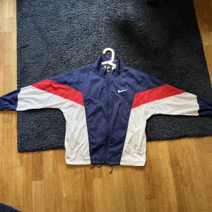 Nike vindjacka - Snygg vindjacka från Nike. Fint skick dock lite skrynklig. Storleken är XS men på mig som är 170 passar den bra (nästan lite stor). Skriv om du har några frågor! 😊